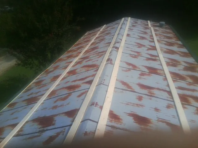 Rusted metal roof panels with new wood purlins before replacement — Storm Damage Roof Repair in Jarrell by Roofing Brothers