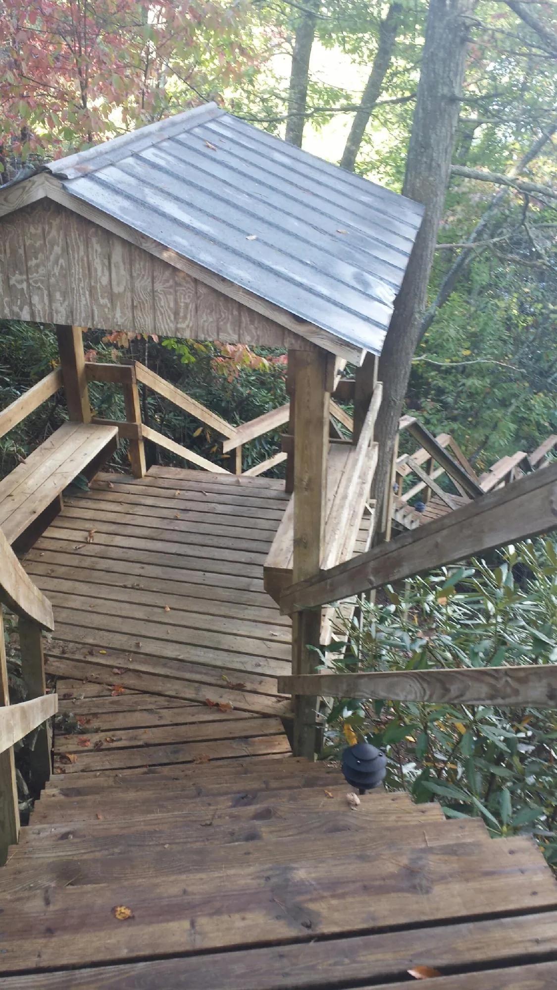 Metal roofed shelter over wooden steps on a wooded walkway — Skylight Repair & Installation work by our crew in Jarrell