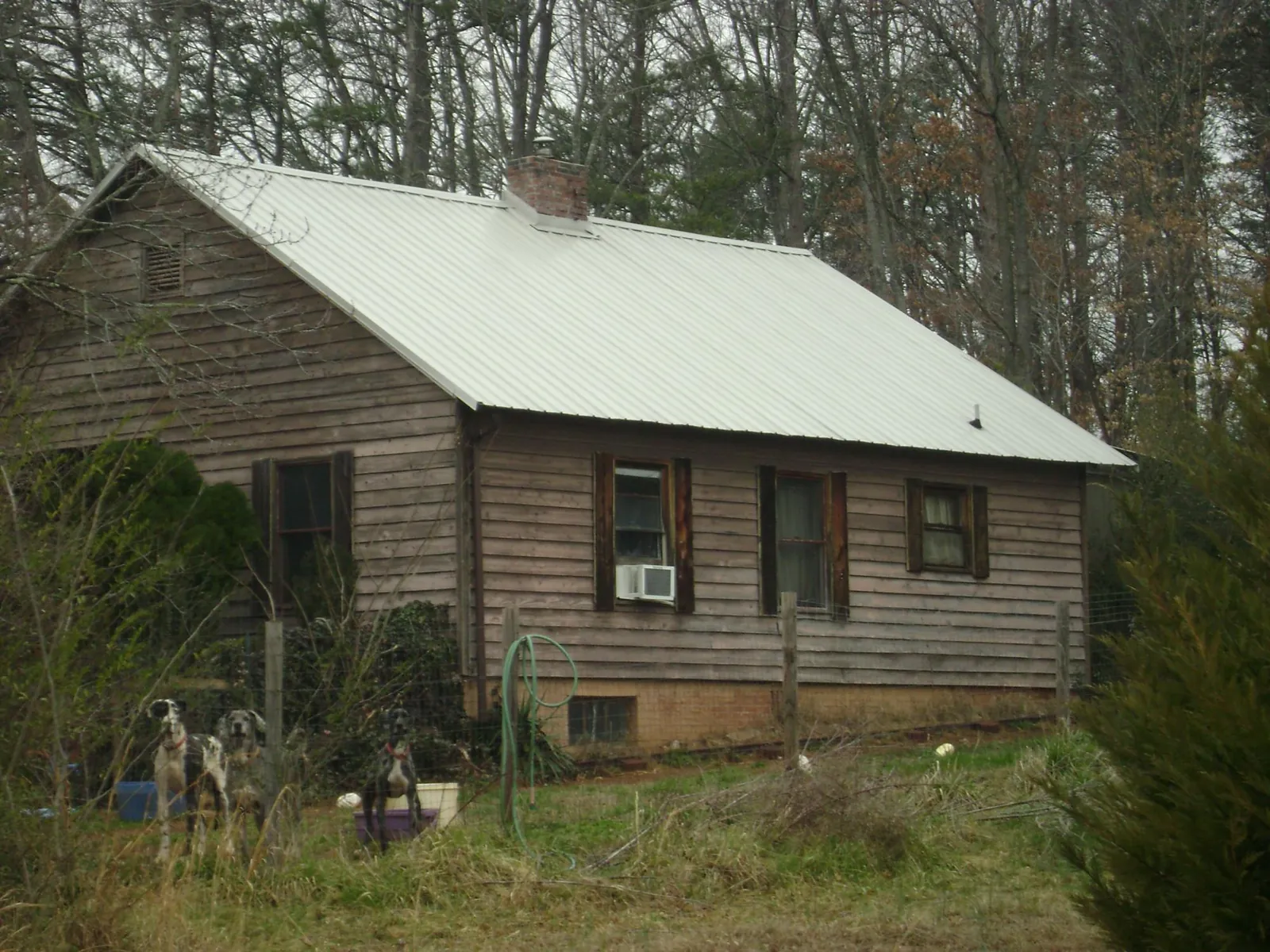 White metal roof on an old wood sided farmhouse, from a Asphalt Shingle Roof Repair job in Jarrell